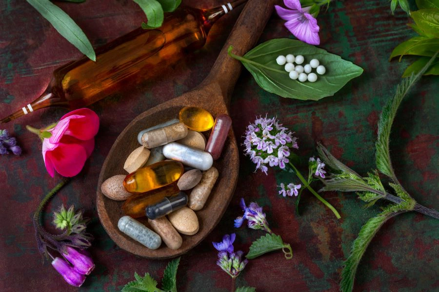 Wooden spoon with different supplement capsules